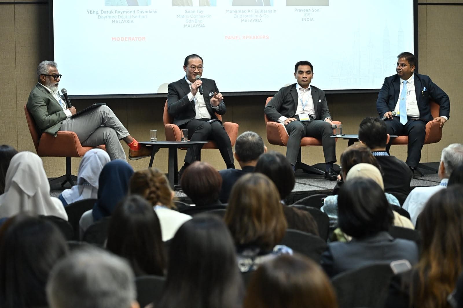 Panel on stage at the CGI Global Governance Summit 2026 discussing how governance professionals can use AI safely, with the audience in the foreground