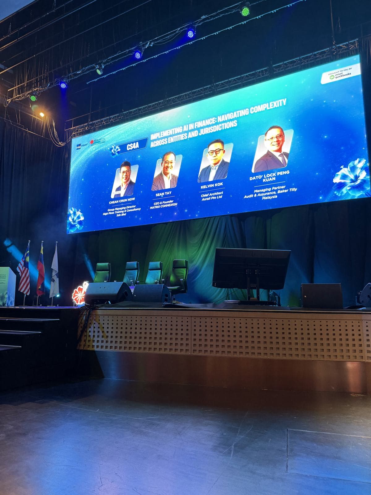 Conference stage screen announcing the AI in Finance session at the MIA International Accountants Conference 2026, with Sean Tay as a panellist